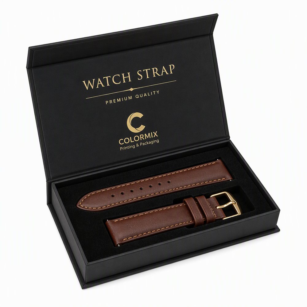 Black magnetic flip-lid box with a die-cut insert holding a brown leather watch strap