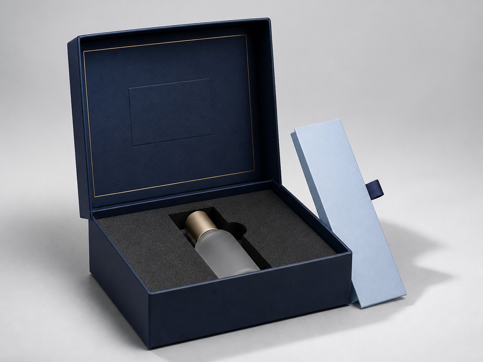 Navy rigid box with gold foil border, soft-touch lamination and a die-cut EVA foam insert holding a cosmetic bottle