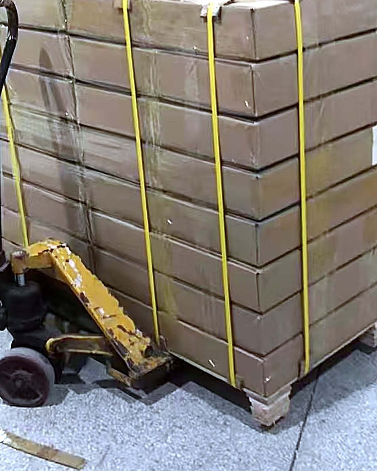 Strapped pallet of cartons on a pallet truck at the loading door